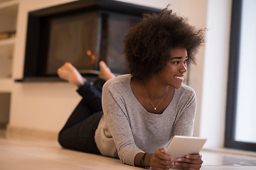 Image showing black women using tablet computer on the floor