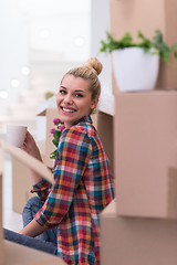 Image showing woman with many cardboard boxes sitting on floor