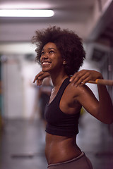 Image showing black woman lifting empty bar