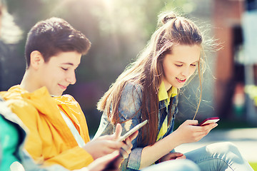 Image showing happy teenage friends with gadgets outdoors