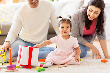 Image showing baby girl with birthday gift and parents at home 