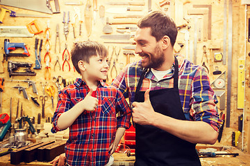 Image showing father and little son making thumbs up at workshop