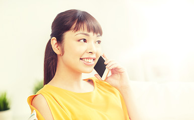 Image showing happy asian woman calling on smartphone at home