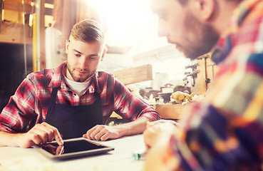 Image showing workmen with tablet pc and blueprint at workshop