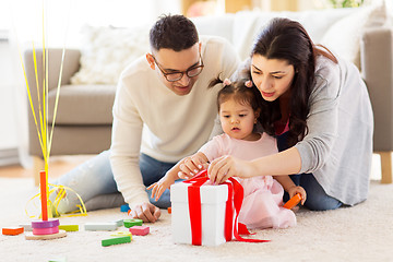 Image showing baby girl with birthday gift and parents at home 