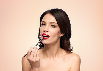 Image showing beautiful woman with make up brush for lipstick