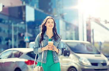 Image showing happy young woman drinking coffee on city street