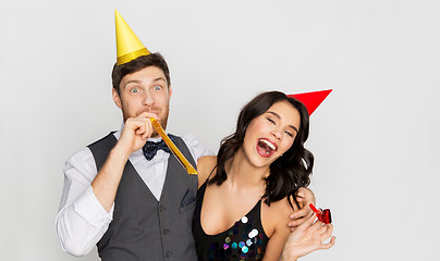 Image showing happy couple with party blowers having fun