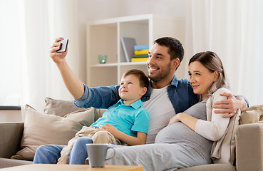 Image showing happy family taking selfie with smartphone at home