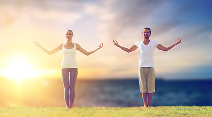 Image showing couple making yoga exercises outdoors