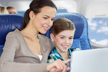 Image showing happy family with tablet pc sitting in plane