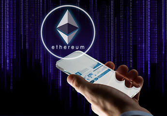 Image showing hand with smartphone and ethereum hologram