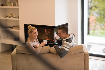 Image showing Young couple  in front of fireplace