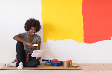 Image showing back female painter sitting on floor