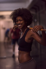 Image showing black woman lifting empty bar