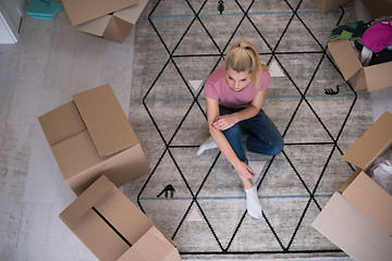 Image showing top view of young beautiful woman sitting on the floor