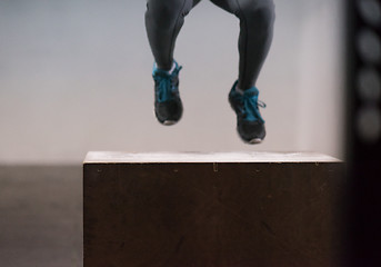 Image showing black woman is performing box jumps at gym