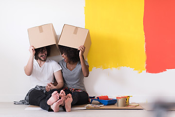 Image showing young multiethnic couple playing with cardboard boxes