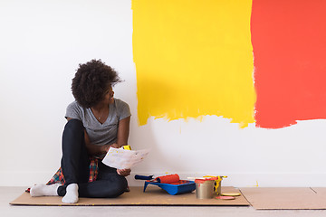 Image showing back female painter sitting on floor