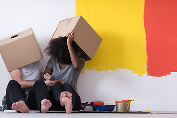 Image showing young multiethnic couple playing with cardboard boxes