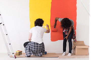 Image showing multiethnic couple painting interior wall