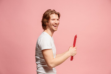 Image showing The happy businessman with red laptop on pink