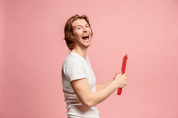 Image showing The happy businessman with red laptop on pink