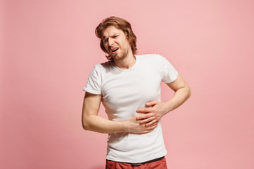 Image showing Young man overwhelmed with a pain in the stomach .