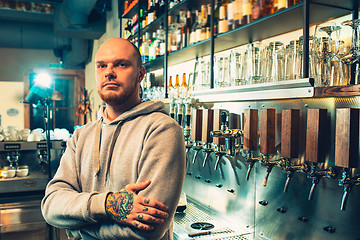 Image showing Barman in a pub near beer taps