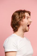 Image showing The young attractive man looking suprised isolated on pink