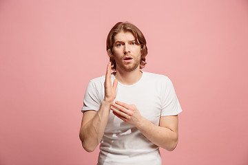 Image showing Let me think. Doubtful pensive man with thoughtful expression making choice against pink background