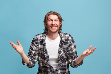 Image showing Beautiful man looking suprised isolated on blue