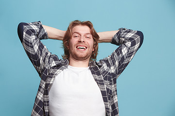 Image showing The happy business man standing and smiling against blue background.