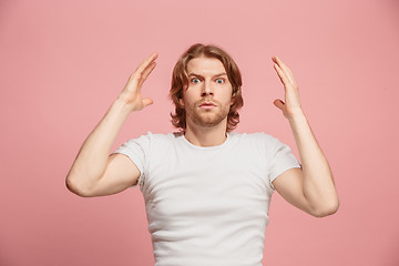 Image showing Beautiful man looking suprised isolated on pink