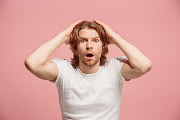 Image showing Beautiful man looking suprised isolated on pink