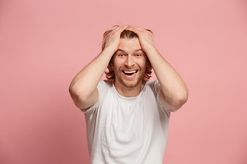 Image showing The happy business man standing and smiling against pink background.