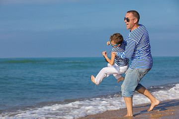 Image showing Father and son playing on the beach at the day time. Concept of 