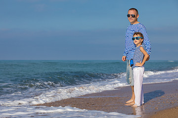 Image showing Father and son playing on the beach at the day time. Concept of 