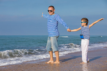 Image showing Father and son playing on the beach at the day time. Concept of 