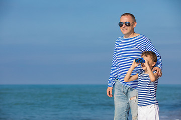 Image showing Father and son playing on the beach at the day time. Concept of 