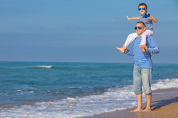 Image showing Father and son playing on the beach at the day time. Concept of 