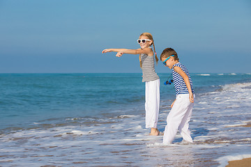 Image showing Two happy children playing on the beach at the day time