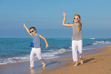 Image showing Two happy children playing on the beach at the day time