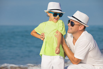 Image showing Father and son playing on the beach at the day time. Concept of 