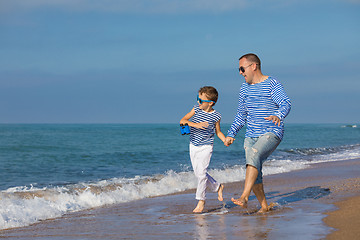 Image showing Father and son playing on the beach at the day time. Concept of 