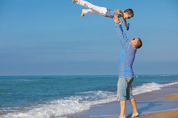 Image showing Father and son playing on the beach at the day time. Concept of 
