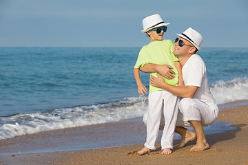 Image showing Father and son playing on the beach at the day time. Concept of 