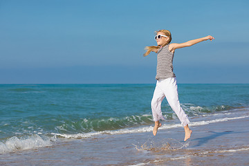 Image showing One happy little girl playing on the beach at the day time