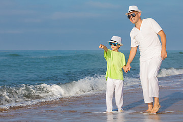 Image showing Father and son playing on the beach at the day time. Concept of 
