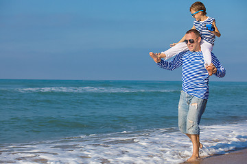 Image showing Father and son playing on the beach at the day time. Concept of 